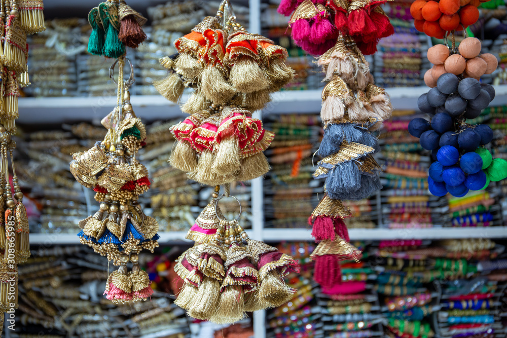 Colorful tailor supplies like ribbons and embroidery material in a street shop in the tailor market in Mumbai, India.
