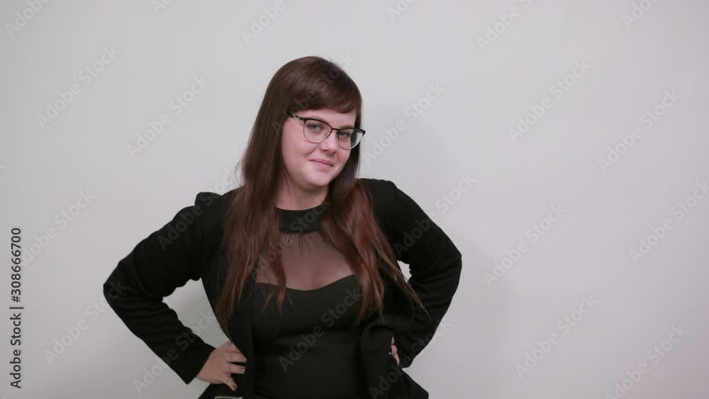 Young caucasian lady wearing white shirt looking so funny, over gray wall background happy and pointing fist directly