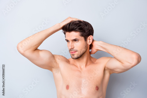 Closeup photo of macho man guy holding hand in perfect hair looking mirror focused naked torso masculine body groomed appearance isolated grey background
