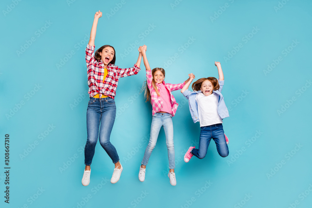 Full length body size photo of two rejoicing daughters with mother winning rejoicing white wearing jeans denim while isolated with blue background Full length body size photo of two rejoicing daughters with mother winning rejoicing white wearing jeans denim while isolated with blue background