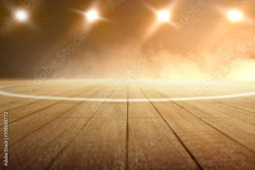 Close up view of a basketball court with wooden floor and spotlights