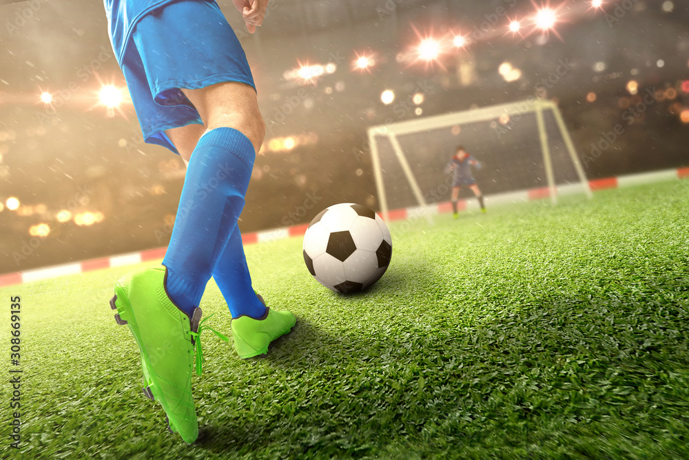 Obraz premium Rear view of football player man kicking the ball on the football field