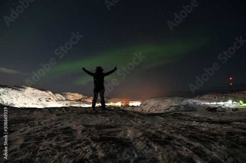 people admire the northern lights in the polar night in the Russian Arctic