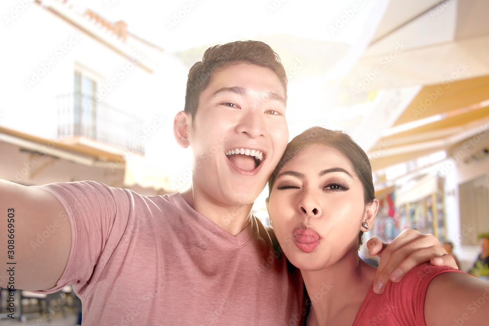 Asian couples making a selfie with a funny face using a camera phone Asian couples making a selfie with a funny face using a camera phone