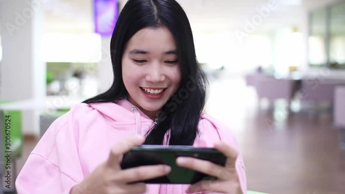 Beautiful Asian women are playing games with fun.young woman using digital tablet at home