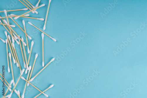 Cotton wooden ear swabs on blue background. Top view. Eco friendly, no plastic