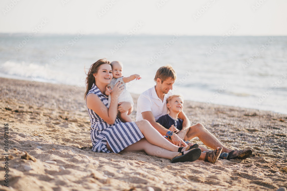 Happy family having fun near sea at the beach.