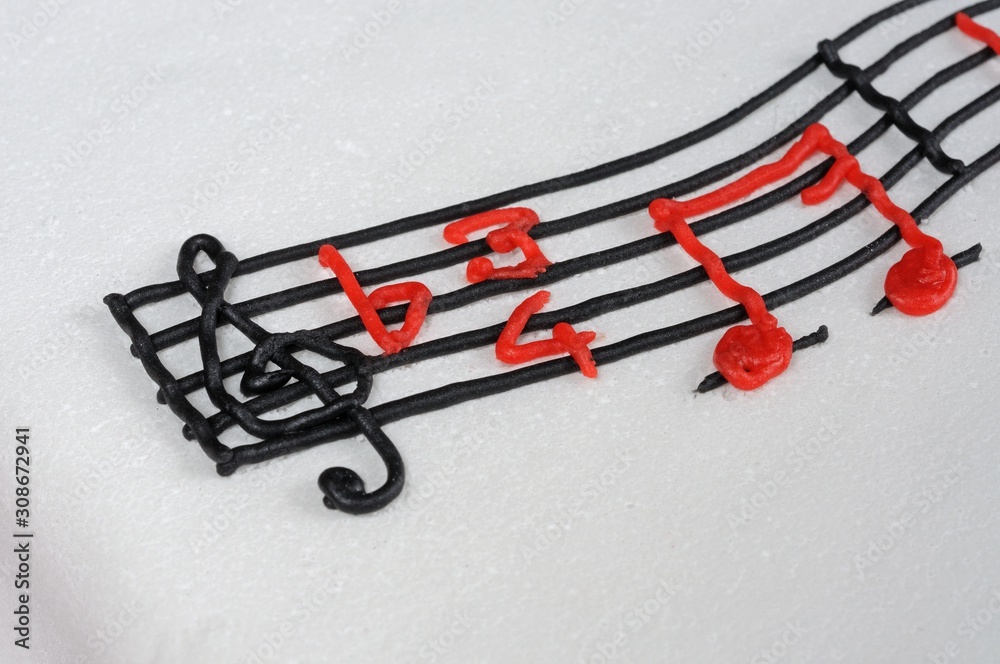 Fototapeta premium White birthday cake with musical stave on top.