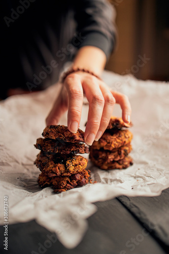 Close up of hand serving freshly baked breakfast cookies on baking paper