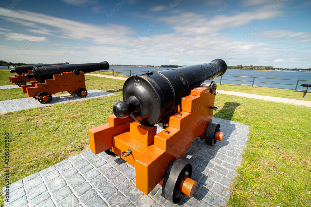 Cannons on the fortified walls of a fortress on the edge of the sea.
