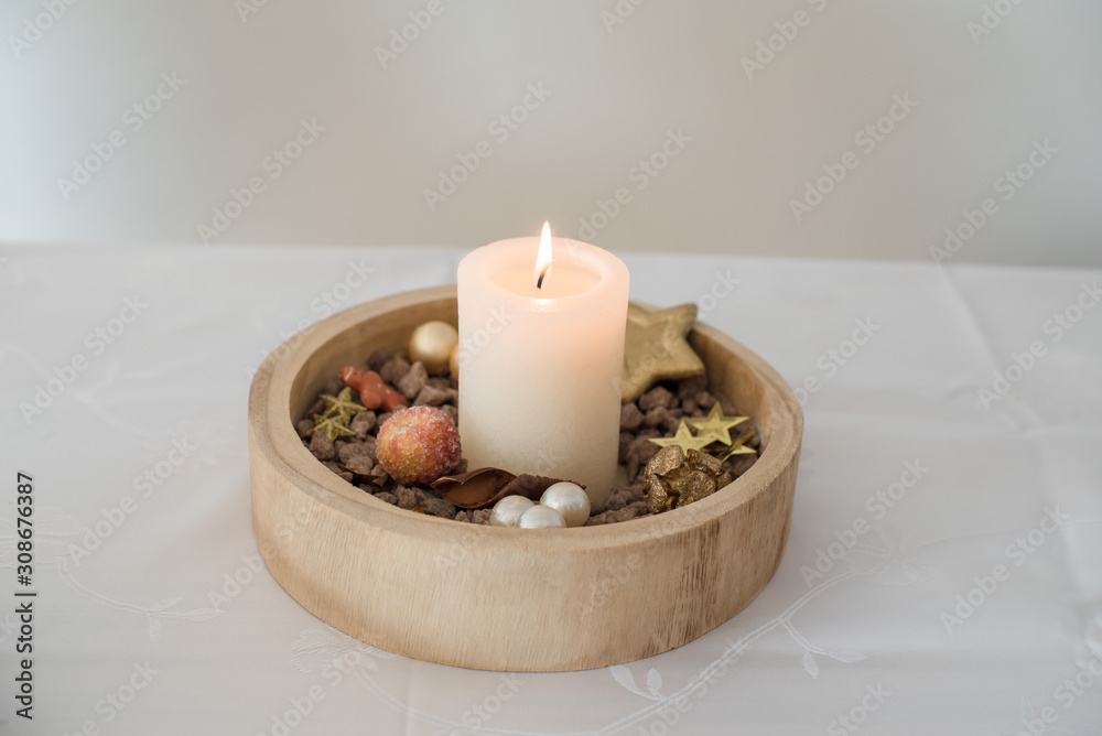 Brennende Kerze in Holzschale mit weihnachtlicher Deko Goldsterne,  kandierter Apfel, Weihnachtskugeln auf einem Tisch mit weißer Tischdecke  Querformat Stock Photo | Adobe Stock