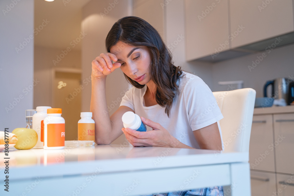 Tired woman with four bottles of pills stock photo Tired woman with four bottles of pills stock photo