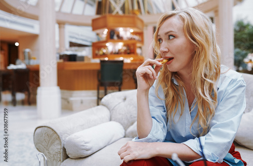Woman enjoying snack and sitting at the hotel lobby