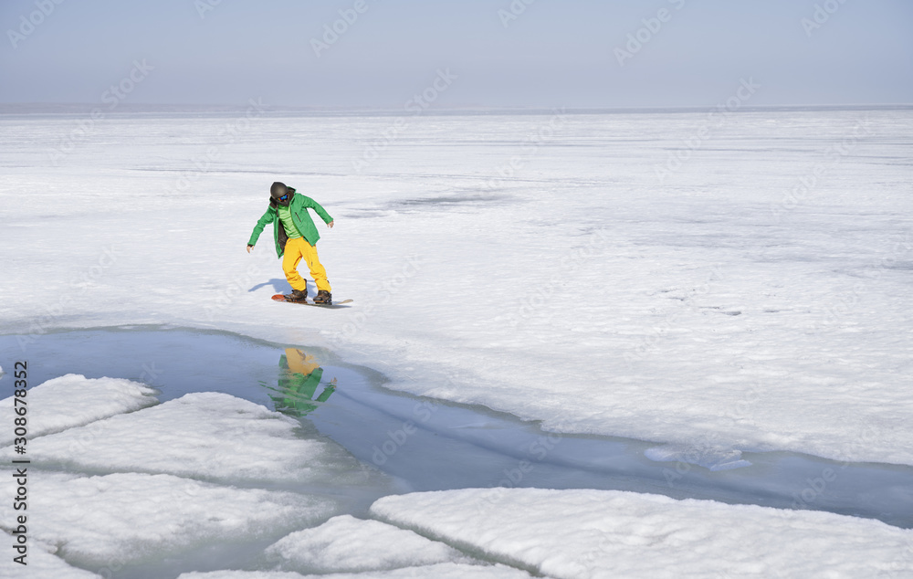 Snowboarding man outdoors in icy and snowy landscape