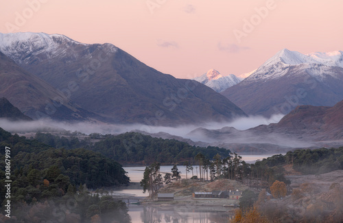 A beautiful sunrise overlooking Loch Affric in the Scottish Highlands. It was a cold winter morning with beautiful soft colors. In the background you can see the mountains covered in snow