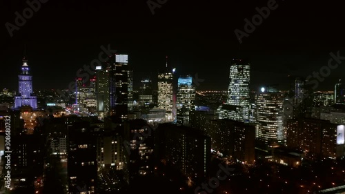 Wallpaper Mural Drone flight between buildings in the city center of Warsaw at night. Poland. 13. December. 2019. Aerial view of the night city with skyscrapers and busy streets with traffic jams during rush hour.  Torontodigital.ca
