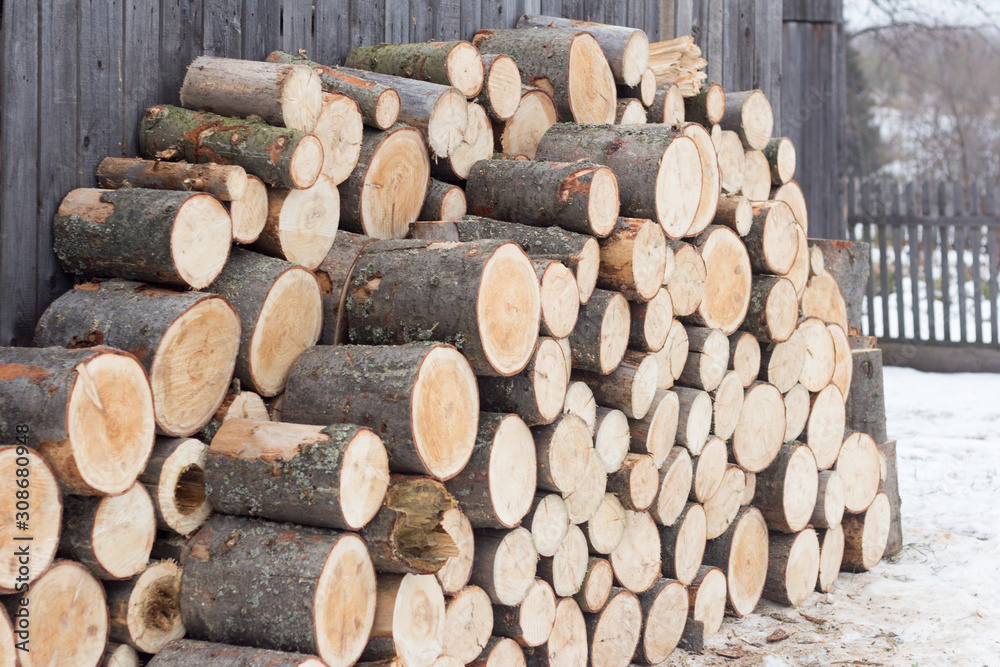 Woodpile of sawn spruce logs. Firewood for heating the house in winter. Woodpile of sawn spruce logs. Firewood for heating the house in winter.