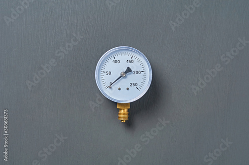Blue manometer for accurate measurement air or gas pressure lies on dark concrete desk in workshop. Top view. Close-up