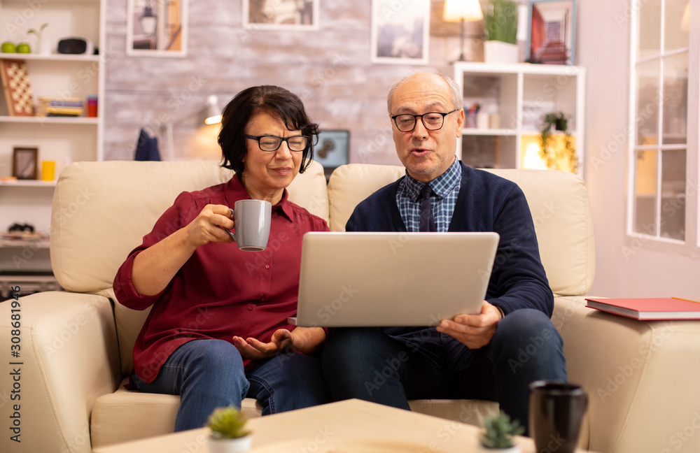 Elderly old couple using modern laptop to chat with their grandson Elderly old couple using modern laptop to chat with their grandson