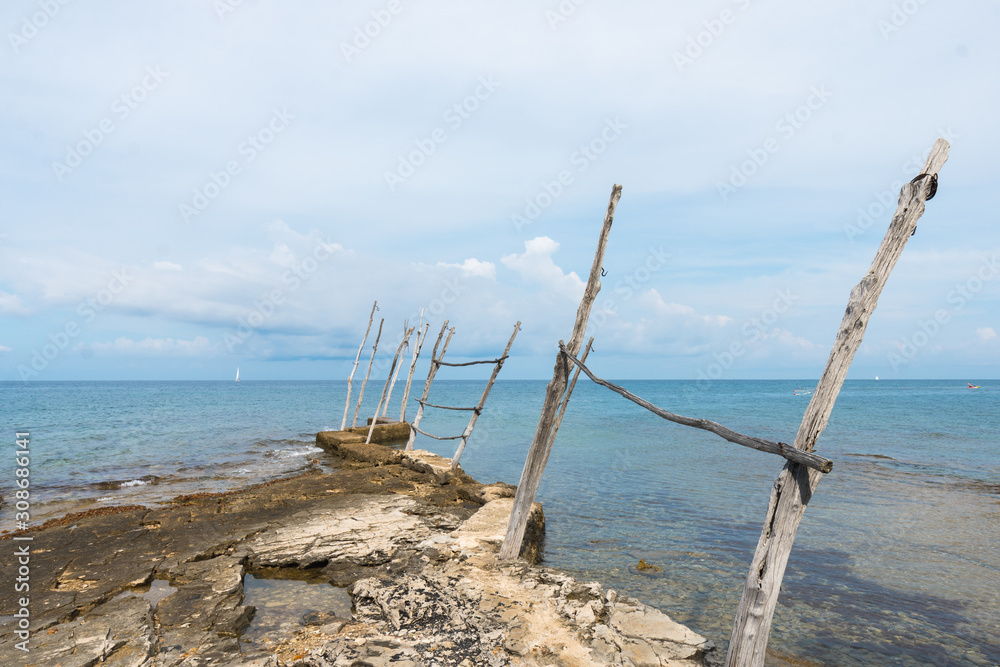 The old piers with the typical wooden cranes of Savudrija, a small fishing village in Croatia The old piers with the typical wooden cranes of Savudrija, a small fishing village in Croatia