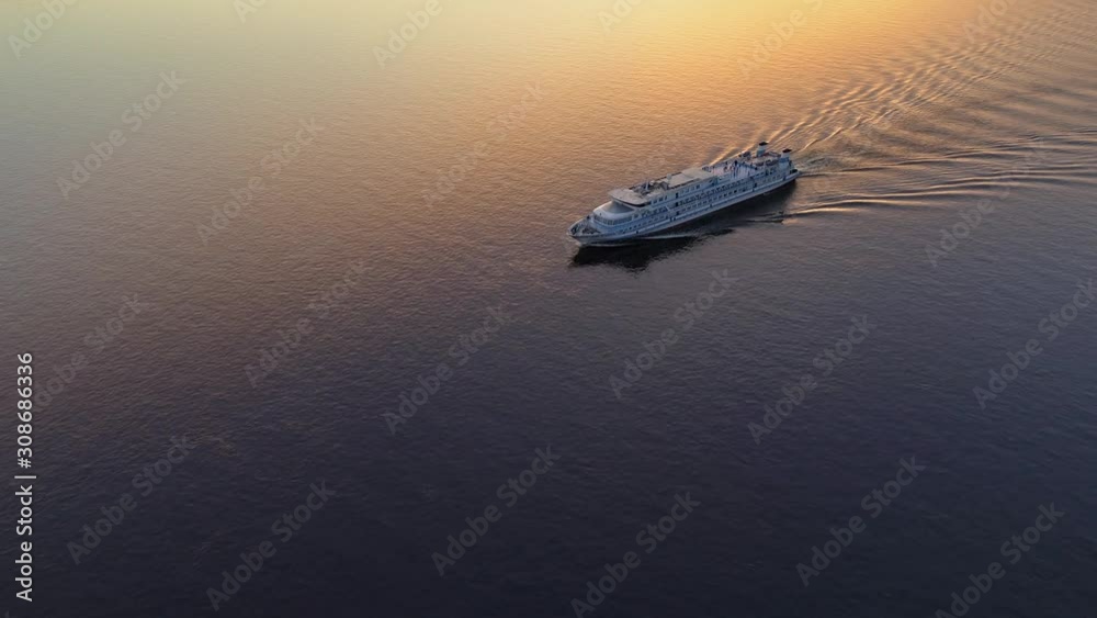 Flight top down cinematic lonely cruise ship boat vessel floating on calm river lake sea beautiful reflection orange sunset in water. Many people tourists on deck Travel tourism discoverer inspiration