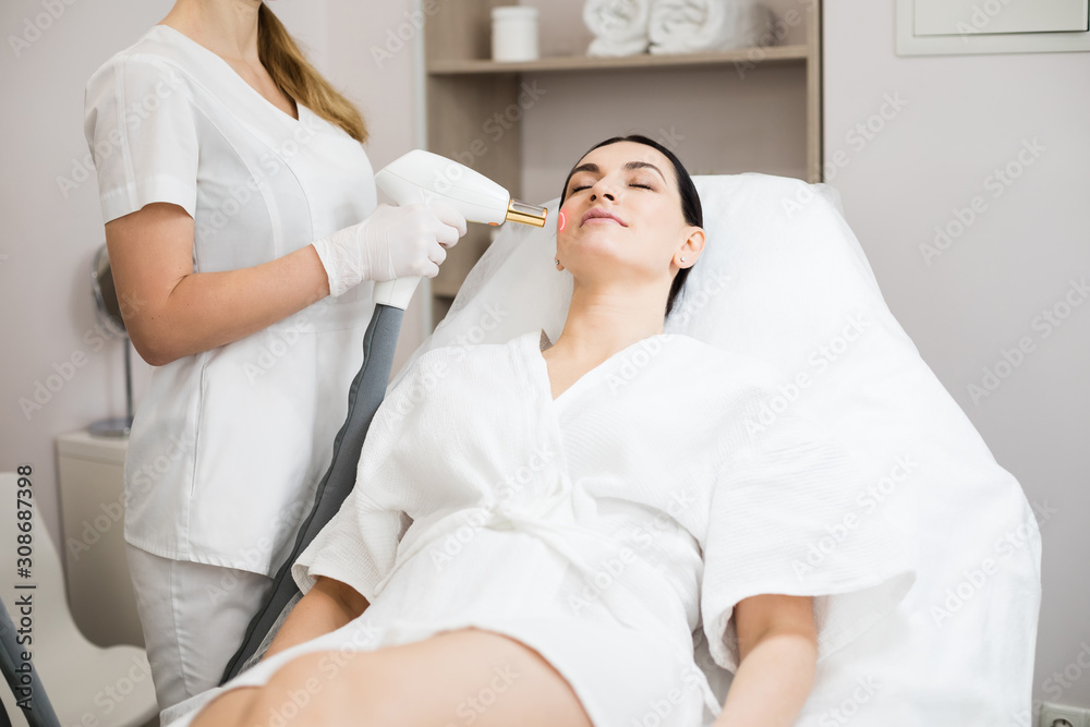 Hardware cosmetology. Face skin care. Skin remodeling. Woman getting skin laser treatment at cosmetology clinic.