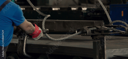 Worker installing big wire rope sling