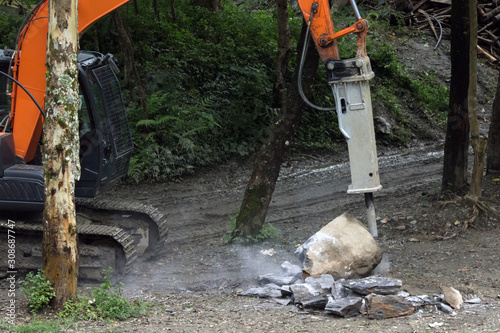 machine with a jackhammer crushes stones