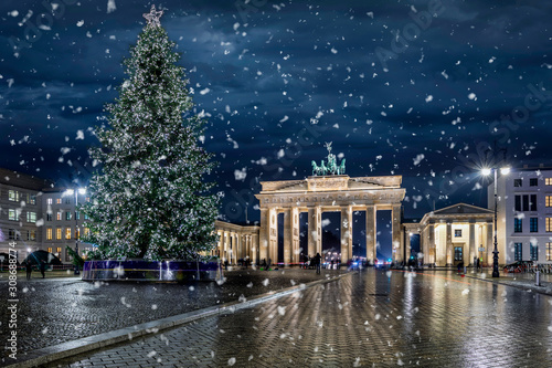 Das Brandenburger Tor in Berlin, Deutschland,  mit Weihnachtsbaum bei Nacht und Schneefall