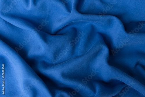 Blue fabric texture background. Textile cloth colored in trend classic blue color of the year 2020. Classic Blue Pantone color. Shallow depth of field, selective focus
