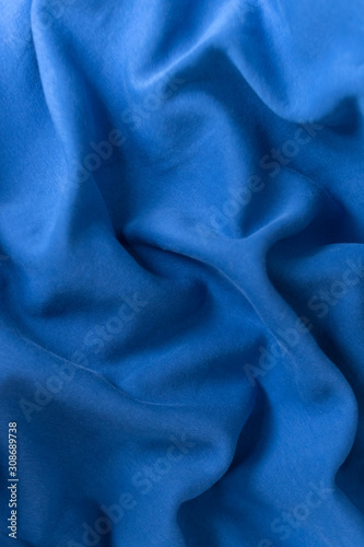 Blue fabric texture background. Textile cloth colored in trend classic blue color of the year 2020. Classic Blue Pantone color. Shallow depth of field, selective focus