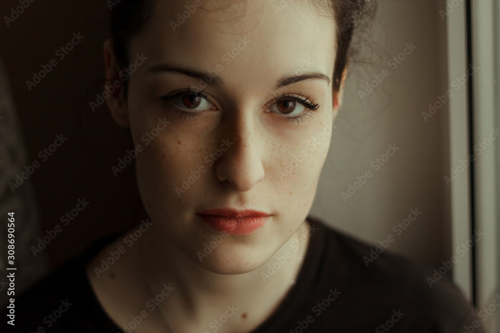 Portrait of a girl with dark hair. With brown big eyes and freckles, white skin. In dark clothes Portrait of a girl with dark hair. With brown big eyes and freckles, white skin. In dark clothes