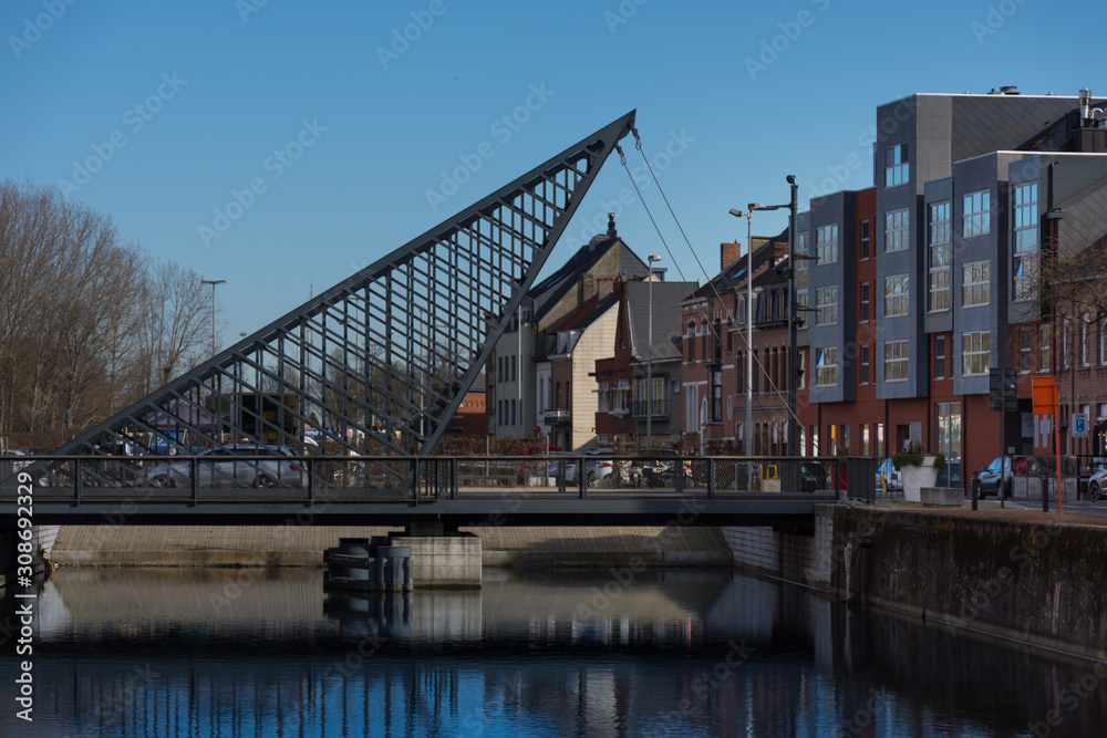 Dendermonde, Belgium - February 24: Vlasmarktbrug, a rocking triangle bridge over the Old Dender river Dendermonde, Belgium - February 24: Vlasmarktbrug, a rocking triangle bridge over the Old Dender river