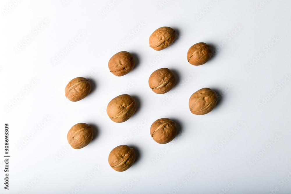 walnuts in symmetry. Close up view of walnuts. Walnuts are water, protein, fat and carbohydrates, including dietary fiber. In a reference portion of grams. A group of brown nuts arranged symmetrically