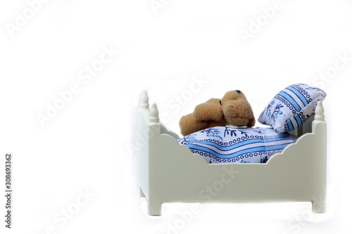 Teddy bear on a bed isolated on white background