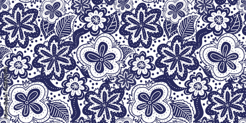 A seamless vector pattern with florals in dark blue and white. Decorative surface print design. Great for fabrics, stationery, and home decor.