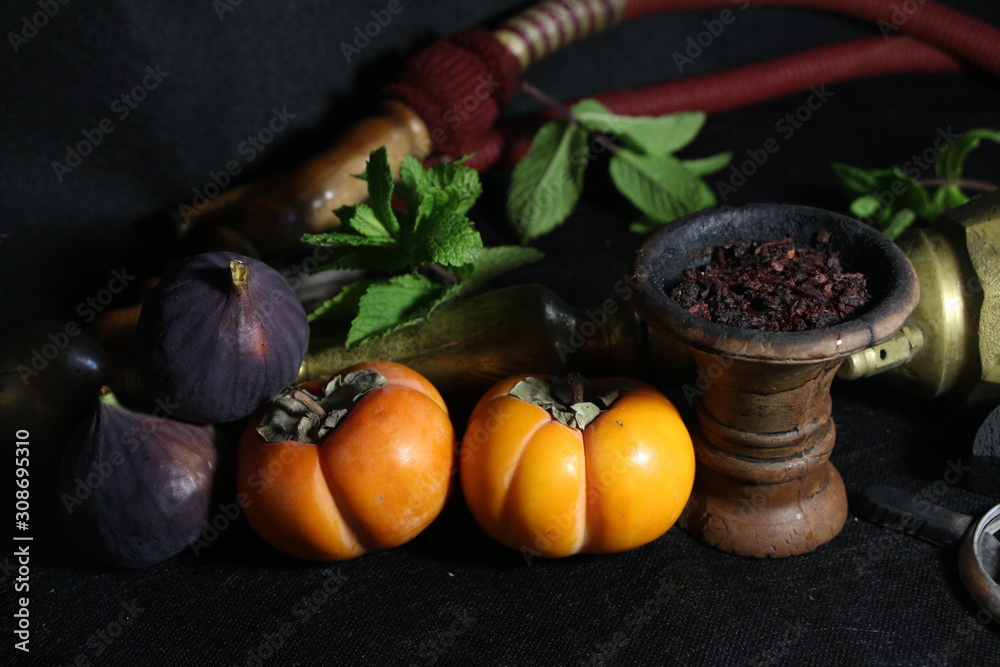 bowl with tobacco for hookah. fruits on a dark background. smoking hookah bowl with tobacco for hookah. fruits on a dark background. smoking hookah