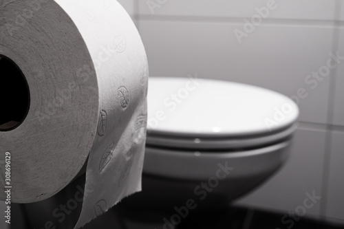nahaufnahme von klopapier mit einer toilette im hintergrund