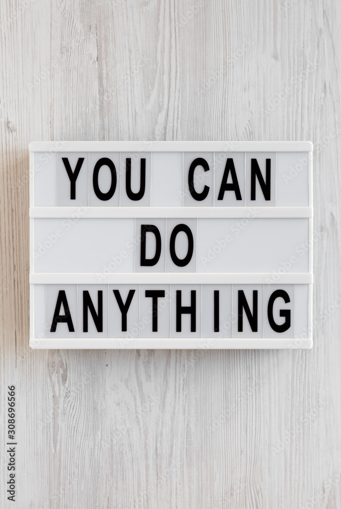 'You can do anything' words on a modern board on a white wooden background, top view. Overhead, from above, flat lay. 'You can do anything' words on a modern board on a white wooden background, top view. Overhead, from above, flat lay.