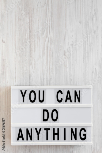 'You can do anything' words on a lightbox on a white wooden background, top view. Overhead, from above, flat lay. Copy space.
