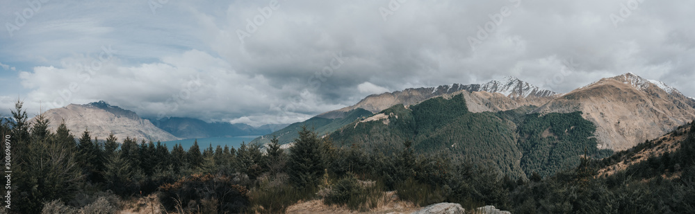 Amazing panoramic view from Queenstown hills with Lake Wakatipu,snow capped mountains and pine forest.