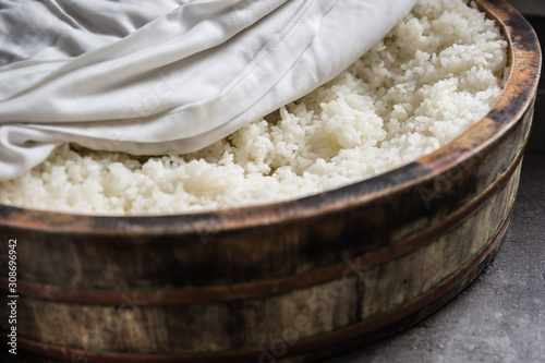 Cooked rice in a typical Japanese wooden vessel hangiri. Pile of rice before ready to prepare sushi photo