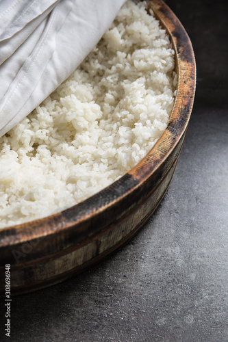 Cooked rice in a typical Japanese wooden vessel hangiri. Pile of rice before ready to prepare sushi photo