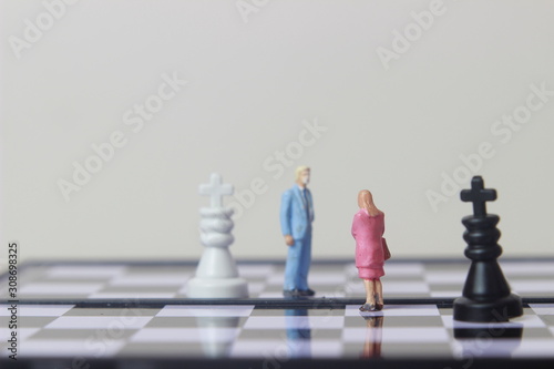 Simple illustration for photo War, Battle or politic situation concept, 2 standing mini figure, man and woman negoitation or debate beyond Small Magnetic Plastic chess