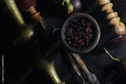 bowl with tobacco for hookah. fruits on a black background. smoking nargile