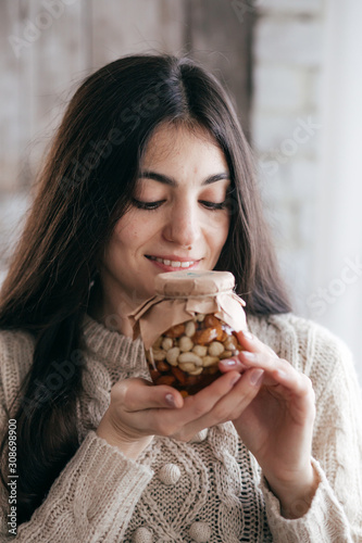 Stock Photo -  Beautiful girl with jars in which honey and nuts