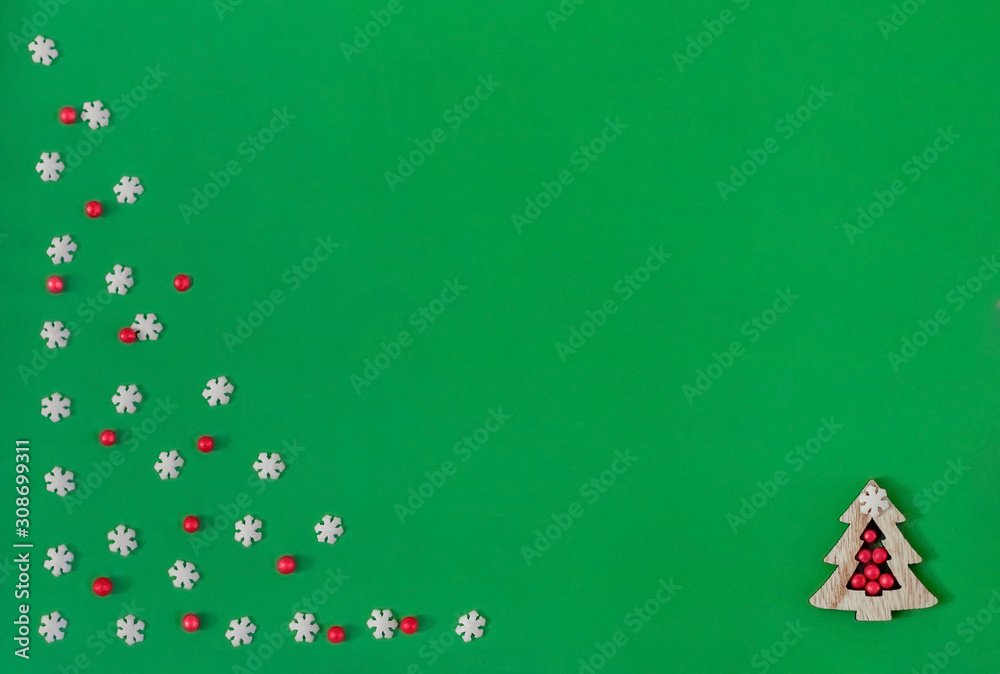 Christmas card wooden tree, red balls and white snowflakes on a green background. Flat lay, top view, copy space, new year, greeting card, greeting, minimalism, winter. Christmas card wooden tree, red balls and white snowflakes on a green background. Flat lay, top view, copy space, new year, greeting card, greeting, minimalism, winter.