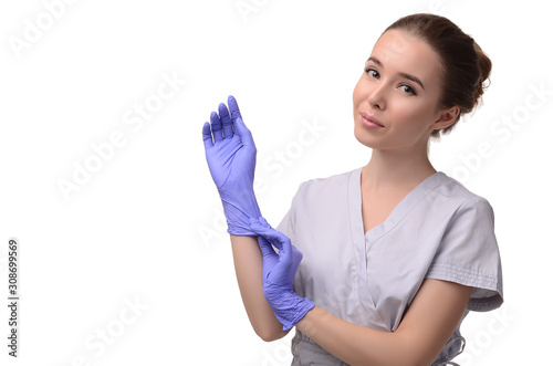 Beautiful female doctor, medical assistant or nurse putting on latex or rubber gloves on white background. Health care concept. Copy space for your text