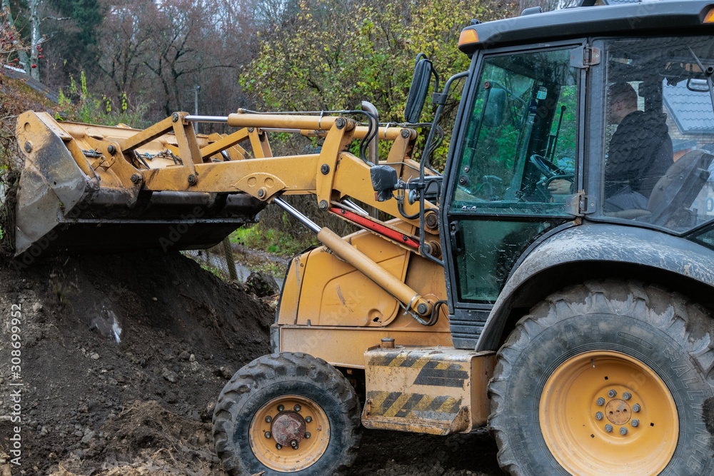 Fragment of the excavator. Repair work on the street of a residential quarter.