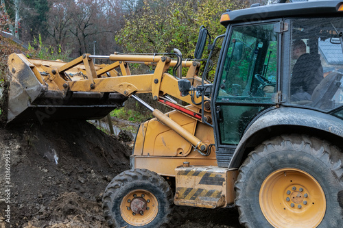 Fragment of the excavator. Repair work on the street of a residential quarter.